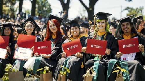 A group of graduates holding certificates.