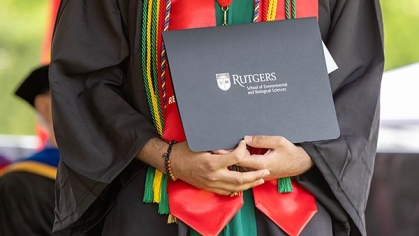 A graduate holding a diploma.