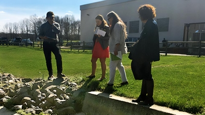 Four people looking at a culvert.