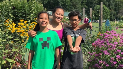 Three children in a flower garden.