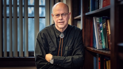 Mike Westendorf standing next to a bookshelf.