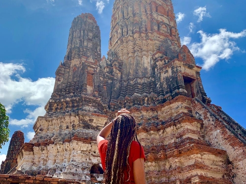 A student staring up at an ancient rock temple.