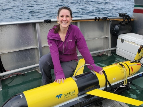 A student posing with an electric glider on a boat.